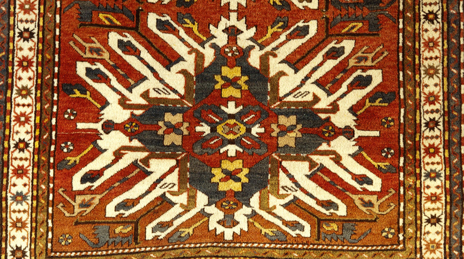 Detail of a red pile carpet with large ivory star medallions